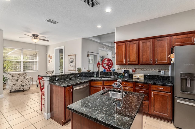 kitchen featuring stainless steel appliances, sink, and a kitchen island with sink