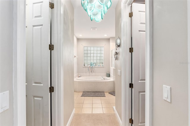 bathroom featuring tile patterned floors and tiled tub