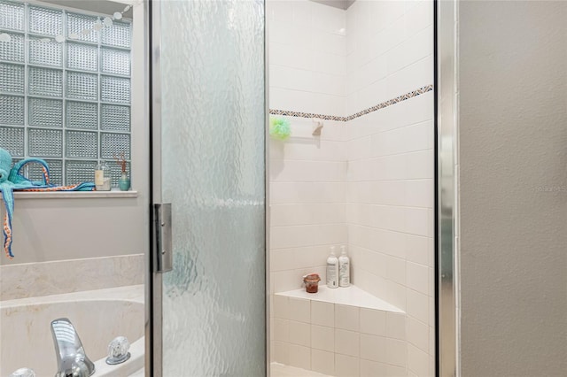 bathroom featuring shower with separate bathtub