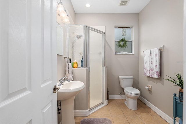 bathroom featuring toilet, an enclosed shower, sink, and tile patterned floors