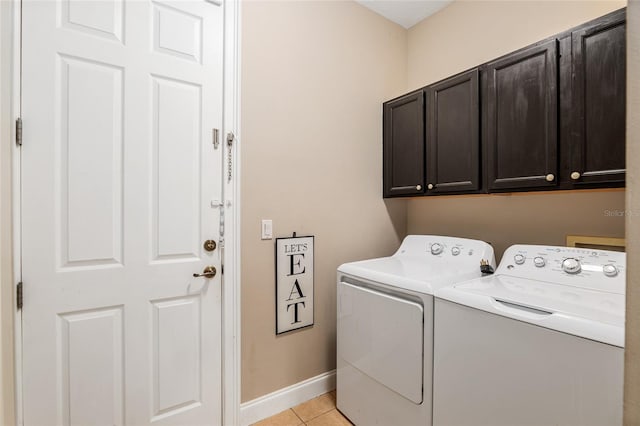 laundry room featuring cabinets, washer and dryer, and light tile patterned floors