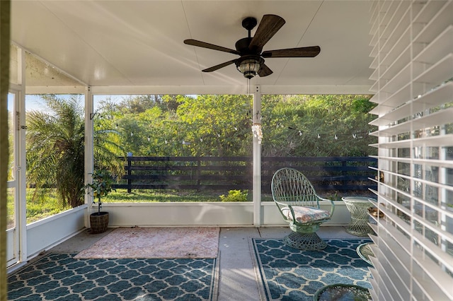 unfurnished sunroom with ceiling fan