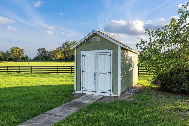 view of outdoor structure with a rural view and a yard