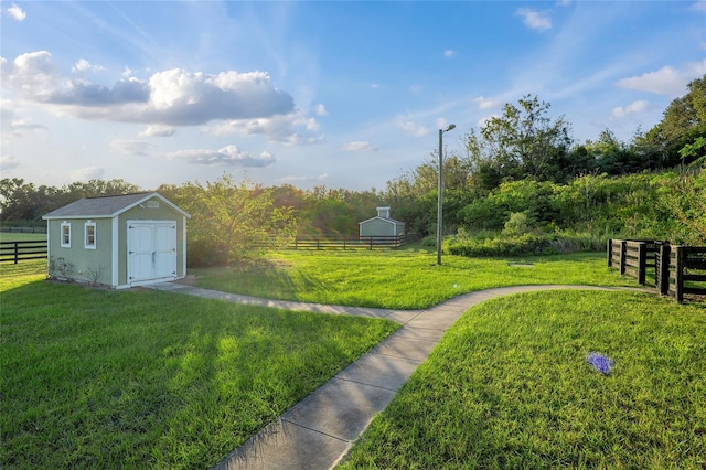 view of yard featuring a rural view and a storage shed