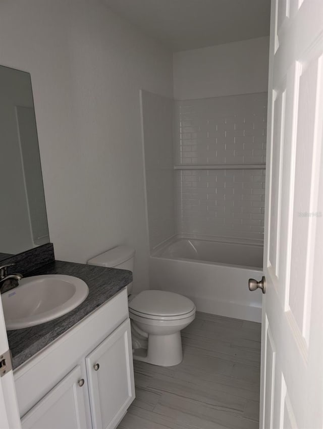 full bathroom with vanity, tiled shower / bath, and toilet