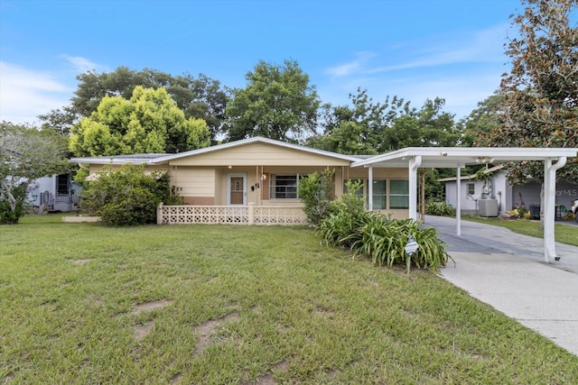 ranch-style home with central air condition unit, a carport, and a front yard