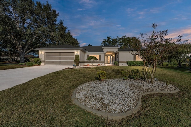 single story home with a garage and a lawn