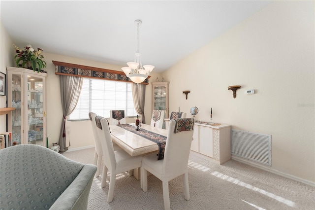 carpeted dining area featuring an inviting chandelier