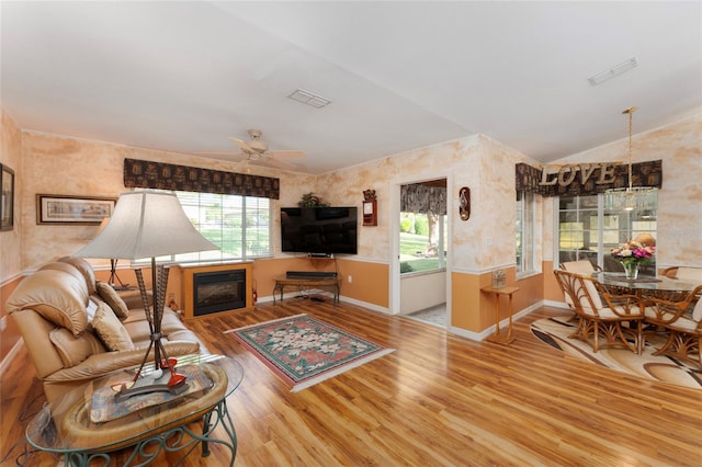 living room with light hardwood / wood-style floors, lofted ceiling, plenty of natural light, and ceiling fan