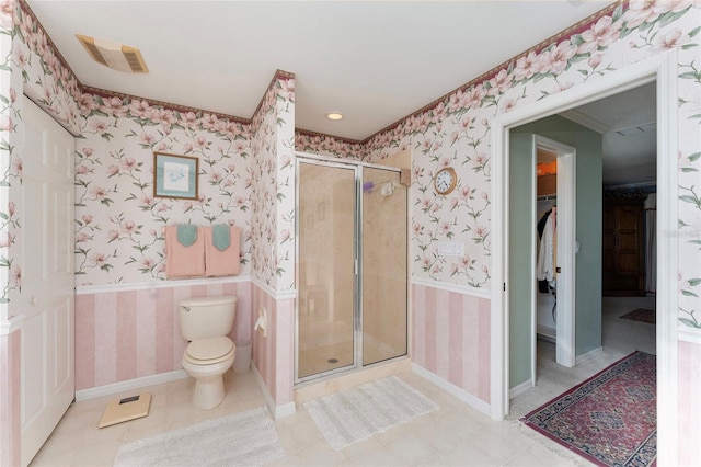 bathroom with tile patterned flooring, toilet, and an enclosed shower