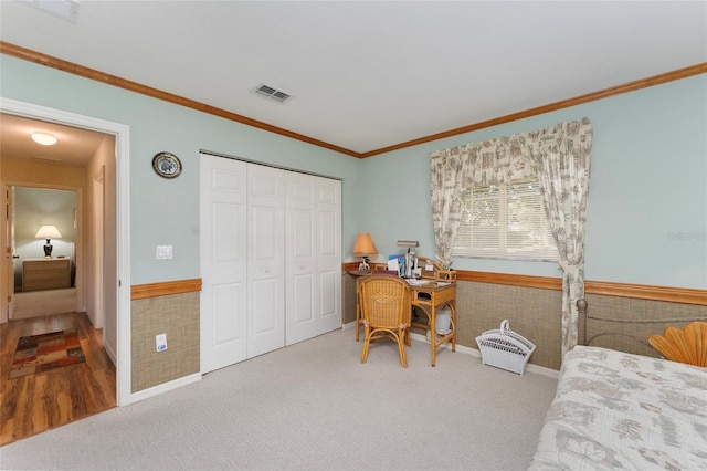 bedroom featuring a closet, carpet flooring, and ornamental molding