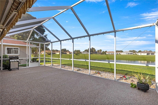 unfurnished sunroom with lofted ceiling and a water view