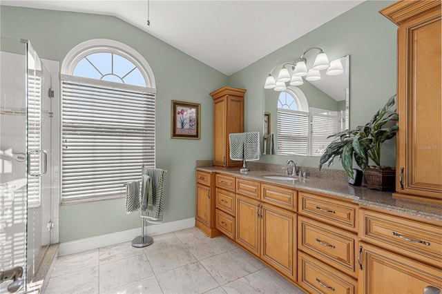 bathroom featuring vanity, vaulted ceiling, and a shower with shower door