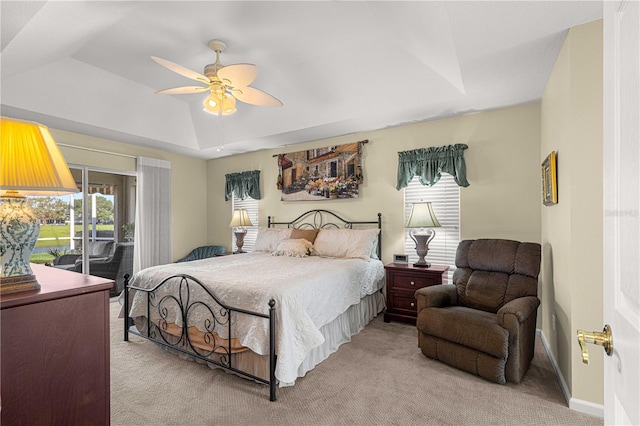 carpeted bedroom featuring ceiling fan, a raised ceiling, and access to outside