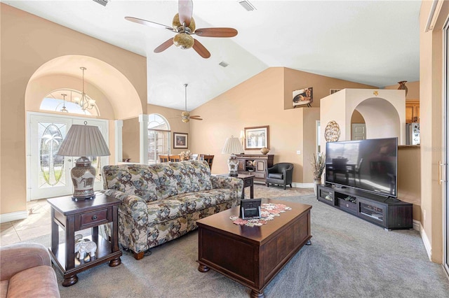 living room featuring ceiling fan with notable chandelier, high vaulted ceiling, and light colored carpet