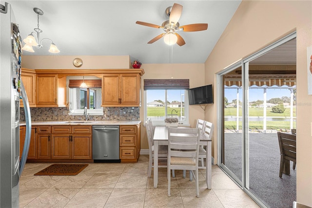 kitchen featuring decorative backsplash, hanging light fixtures, sink, appliances with stainless steel finishes, and ceiling fan with notable chandelier