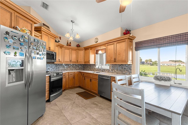 kitchen with stainless steel appliances, sink, vaulted ceiling, decorative light fixtures, and tasteful backsplash