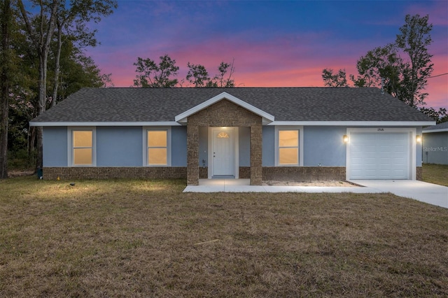 ranch-style home with a garage and a lawn