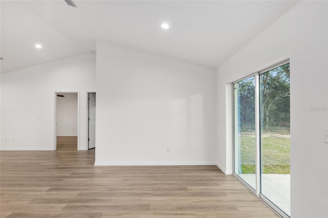 empty room with lofted ceiling and light hardwood / wood-style flooring