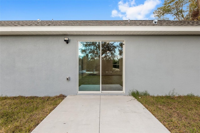 property entrance featuring a patio area and a yard