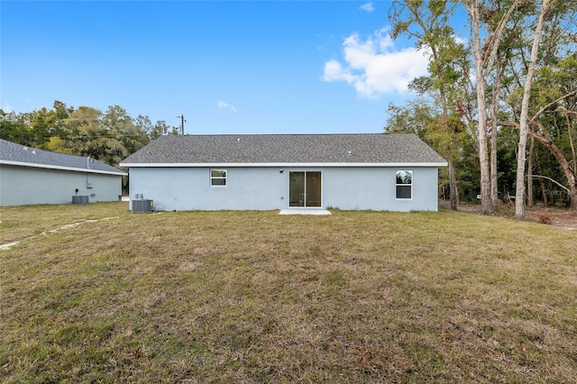 back of house with central AC and a lawn