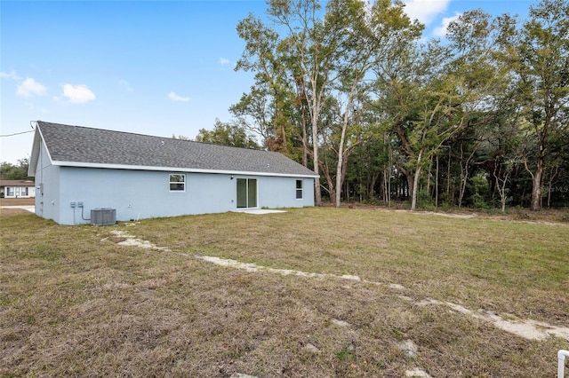 rear view of house with a lawn and central AC unit