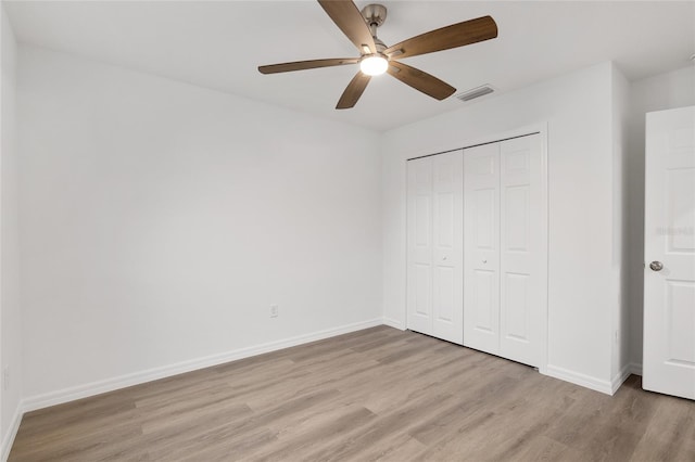 unfurnished bedroom with ceiling fan, a closet, and light hardwood / wood-style flooring