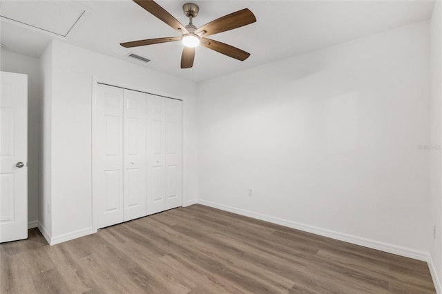 unfurnished bedroom featuring ceiling fan, a closet, and light hardwood / wood-style floors