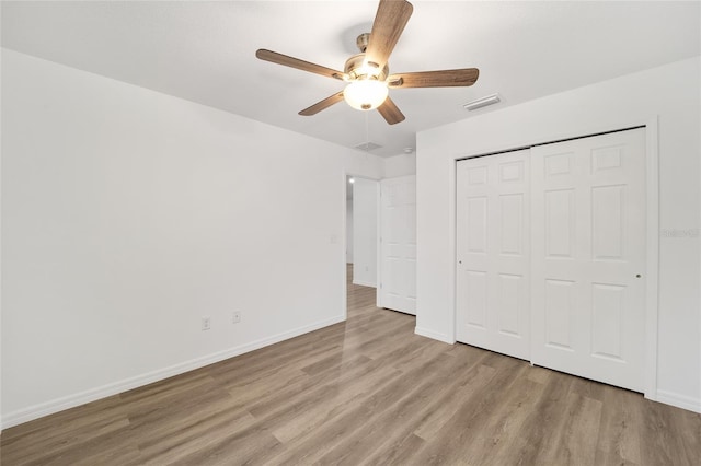 unfurnished bedroom with ceiling fan, a closet, and light hardwood / wood-style floors