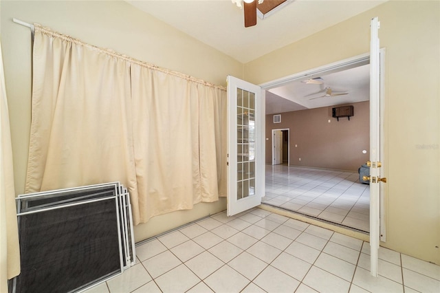 tiled empty room featuring ceiling fan