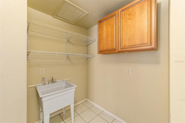 laundry room with a textured ceiling and light tile patterned floors