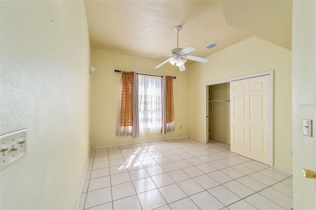 unfurnished bedroom with a closet, ceiling fan, a textured ceiling, and light tile patterned floors