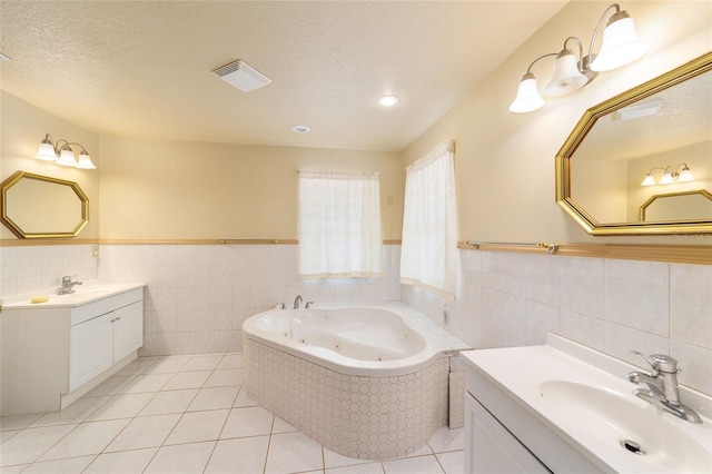 bathroom featuring vanity, a bathtub, a textured ceiling, and tile patterned flooring