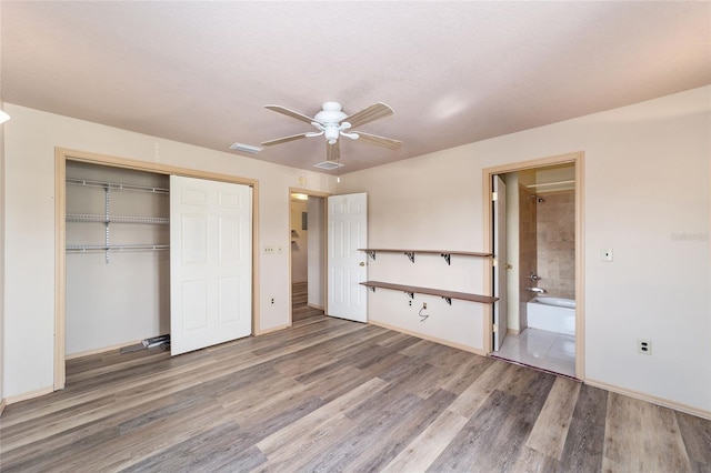 unfurnished bedroom featuring a closet, ceiling fan, hardwood / wood-style flooring, and a textured ceiling