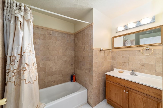 bathroom featuring vanity, a textured ceiling, tile walls, and shower / tub combo