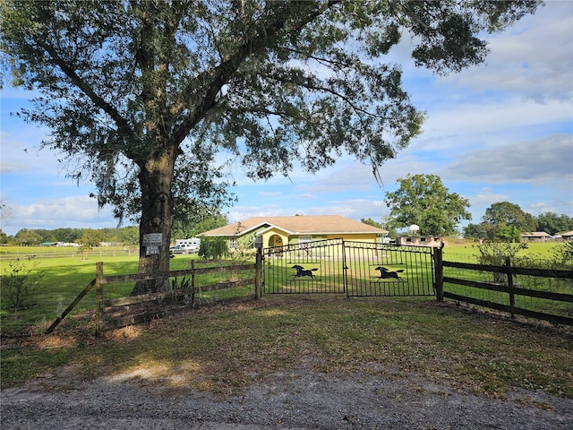 view of gate with a rural view and a yard