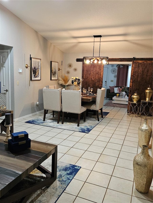 dining space featuring a barn door and light tile patterned floors