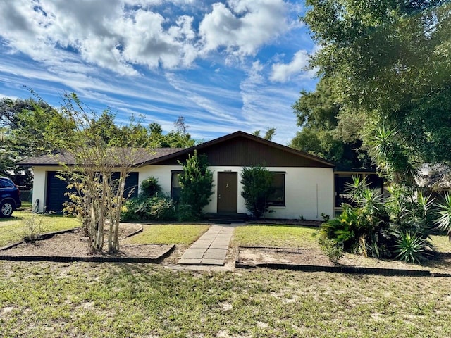 ranch-style home with a front lawn and a garage