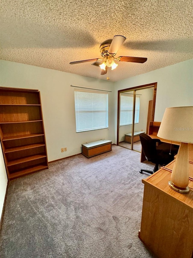 home office with ceiling fan, a textured ceiling, and carpet