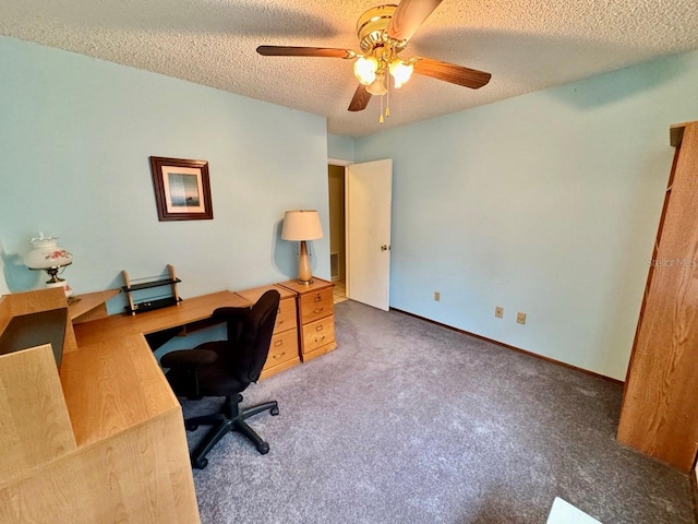 carpeted home office featuring a textured ceiling and ceiling fan