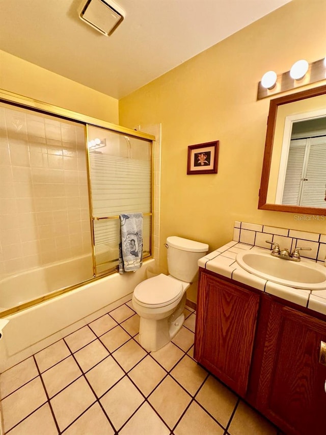 full bathroom featuring shower / bath combination with glass door, tile patterned flooring, toilet, and vanity