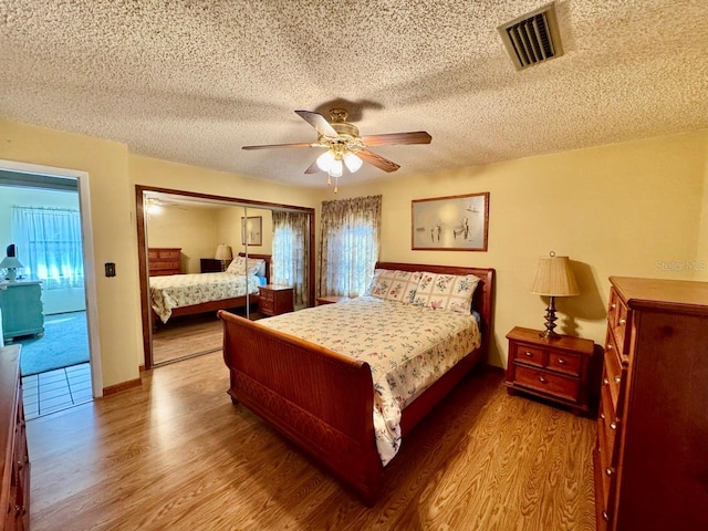 bedroom featuring hardwood / wood-style floors, ceiling fan, and a closet