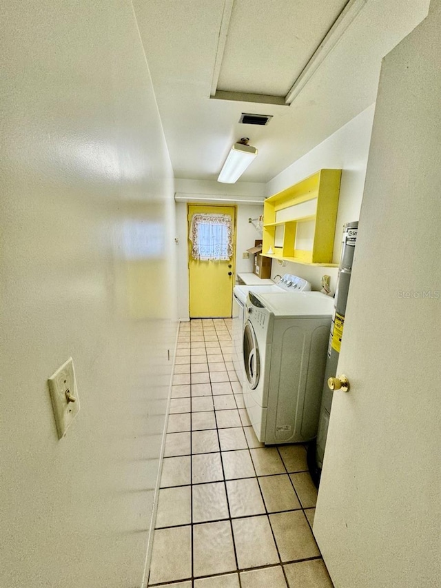 laundry room with light tile patterned flooring and separate washer and dryer