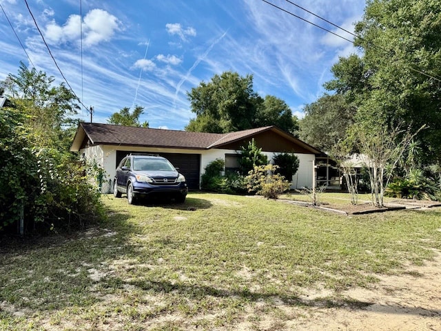 view of side of property featuring a garage and a yard