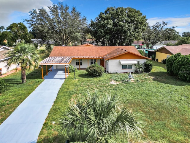 view of front of property featuring a carport, a front lawn, and a garage