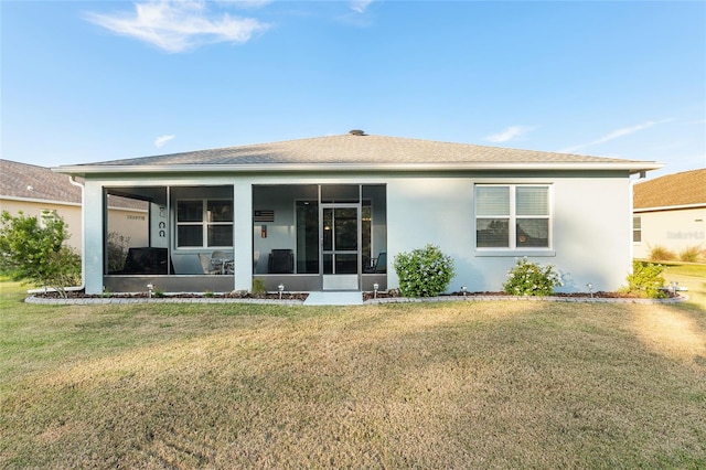 rear view of property with a sunroom and a lawn