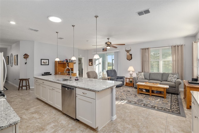 kitchen with light stone countertops, sink, ceiling fan, stainless steel dishwasher, and white cabinets