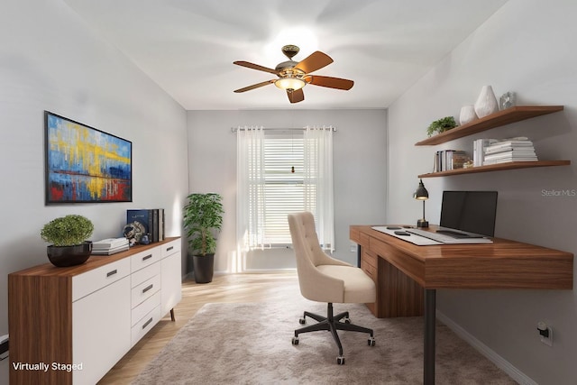 home office with light hardwood / wood-style flooring and ceiling fan