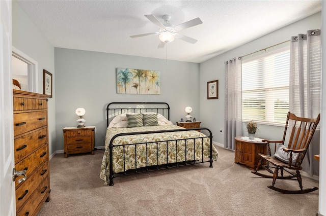 bedroom with ceiling fan, carpet, and a textured ceiling