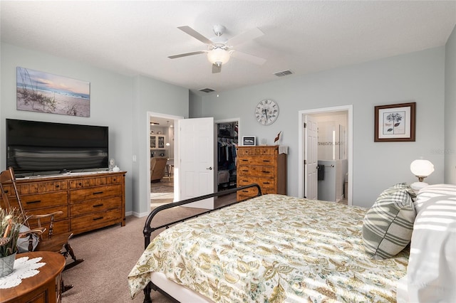 carpeted bedroom with a walk in closet, ensuite bathroom, a textured ceiling, ceiling fan, and a closet